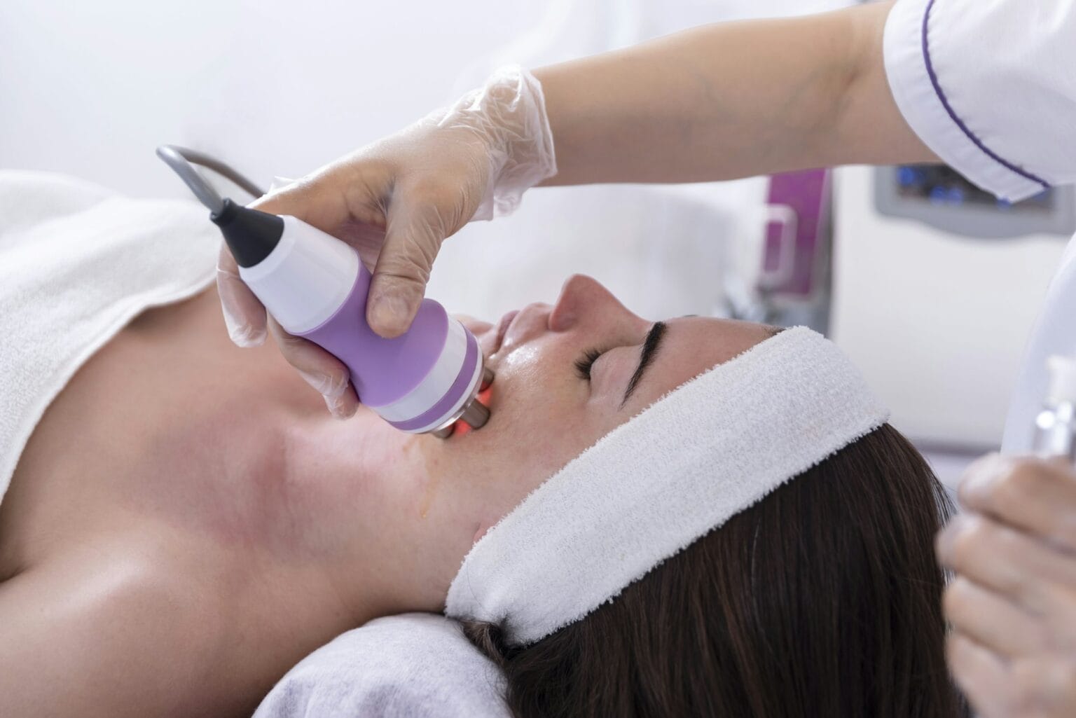 A young woman undergoing a facial radiofrequency face lift treatment.Beauty and dermatology concept.